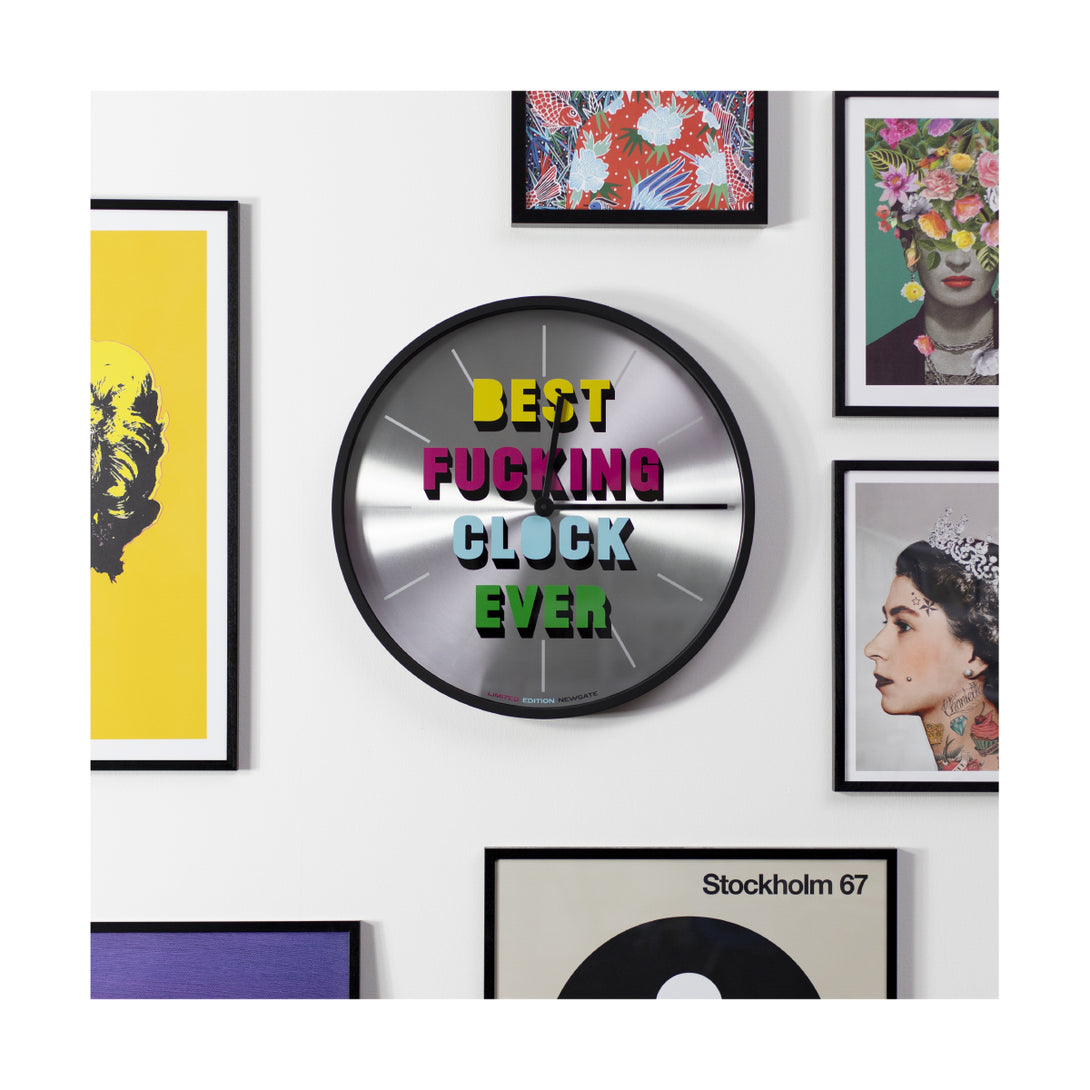 Limited Edition slogan wall clock in spun Aluminium and silicone black by Newgate World on a gallery wall