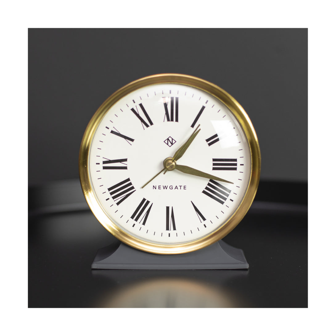 Roman Numeral Gold and Moonstone Grey Hotel Alarm by Newgate World on a table - HOTE455BGY